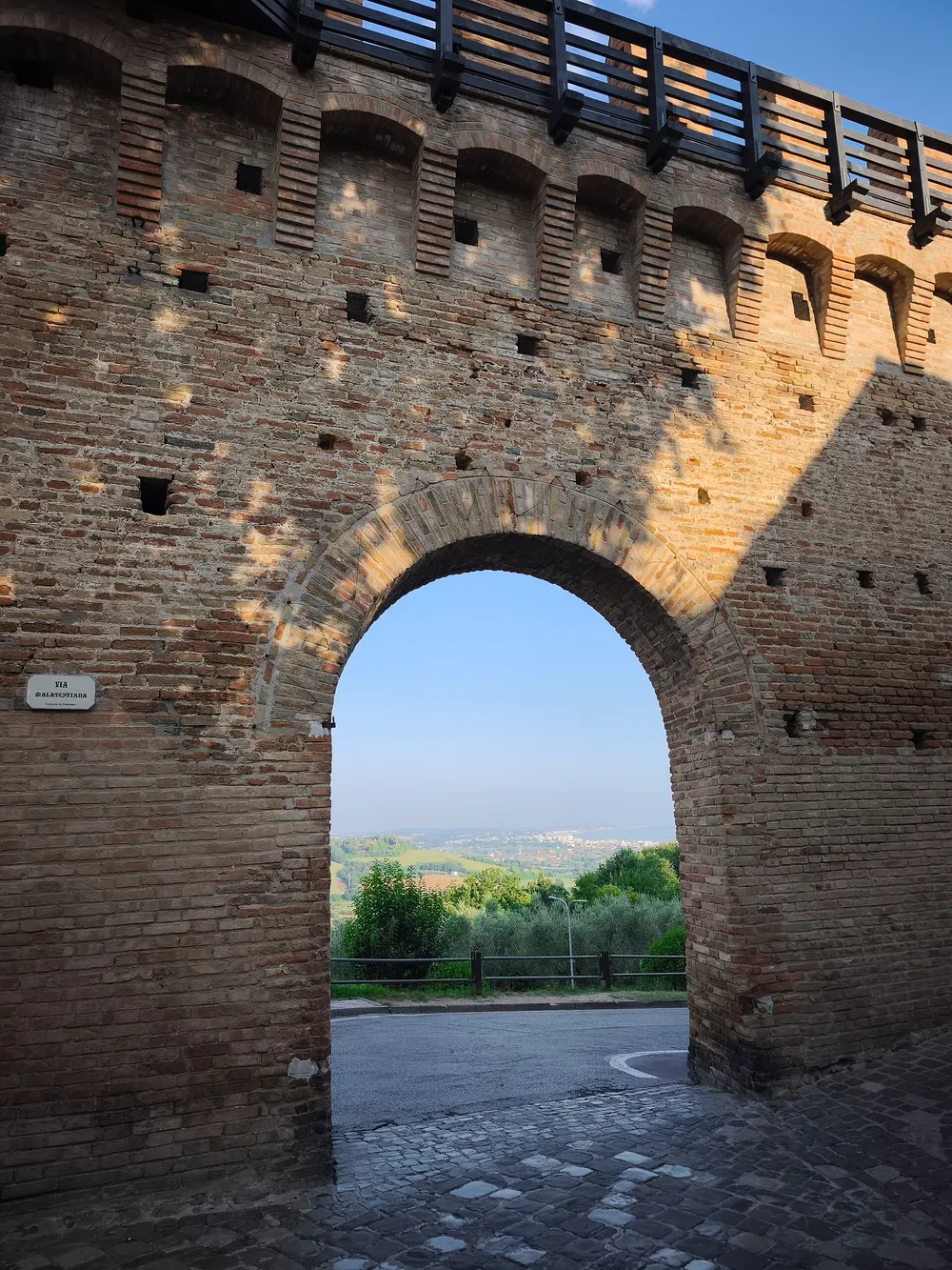 Un arco nelle mura di Gradara con vista sulle colline