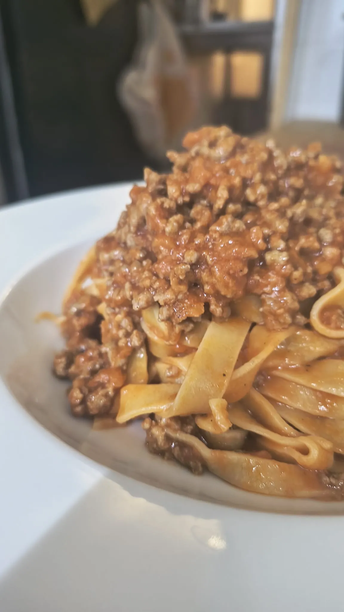 Tagliatelle al ragù in un piatto bianco