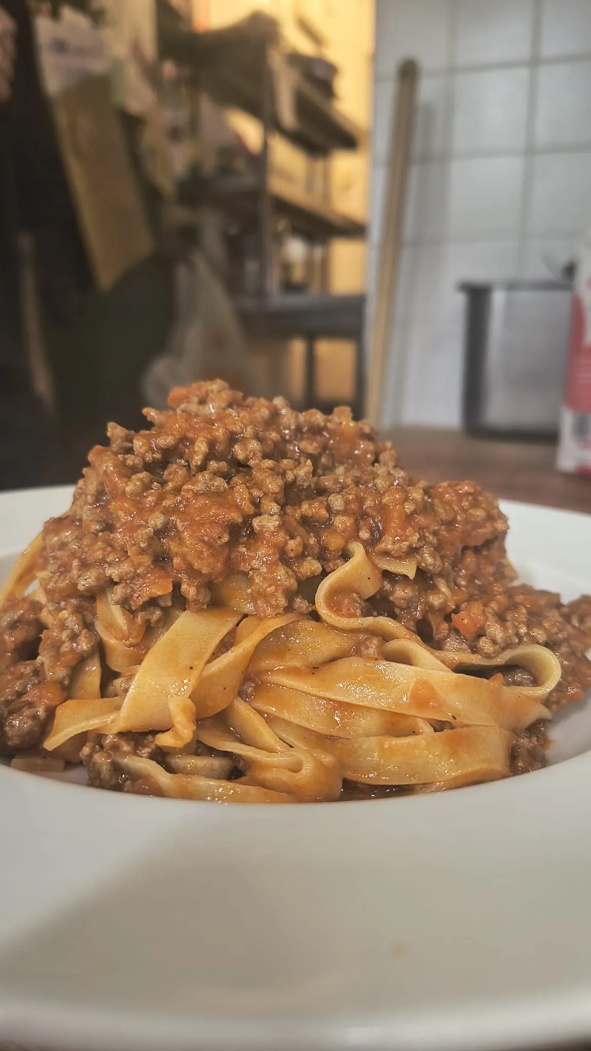 Un piatto di tagliatelle con ragù e basilico