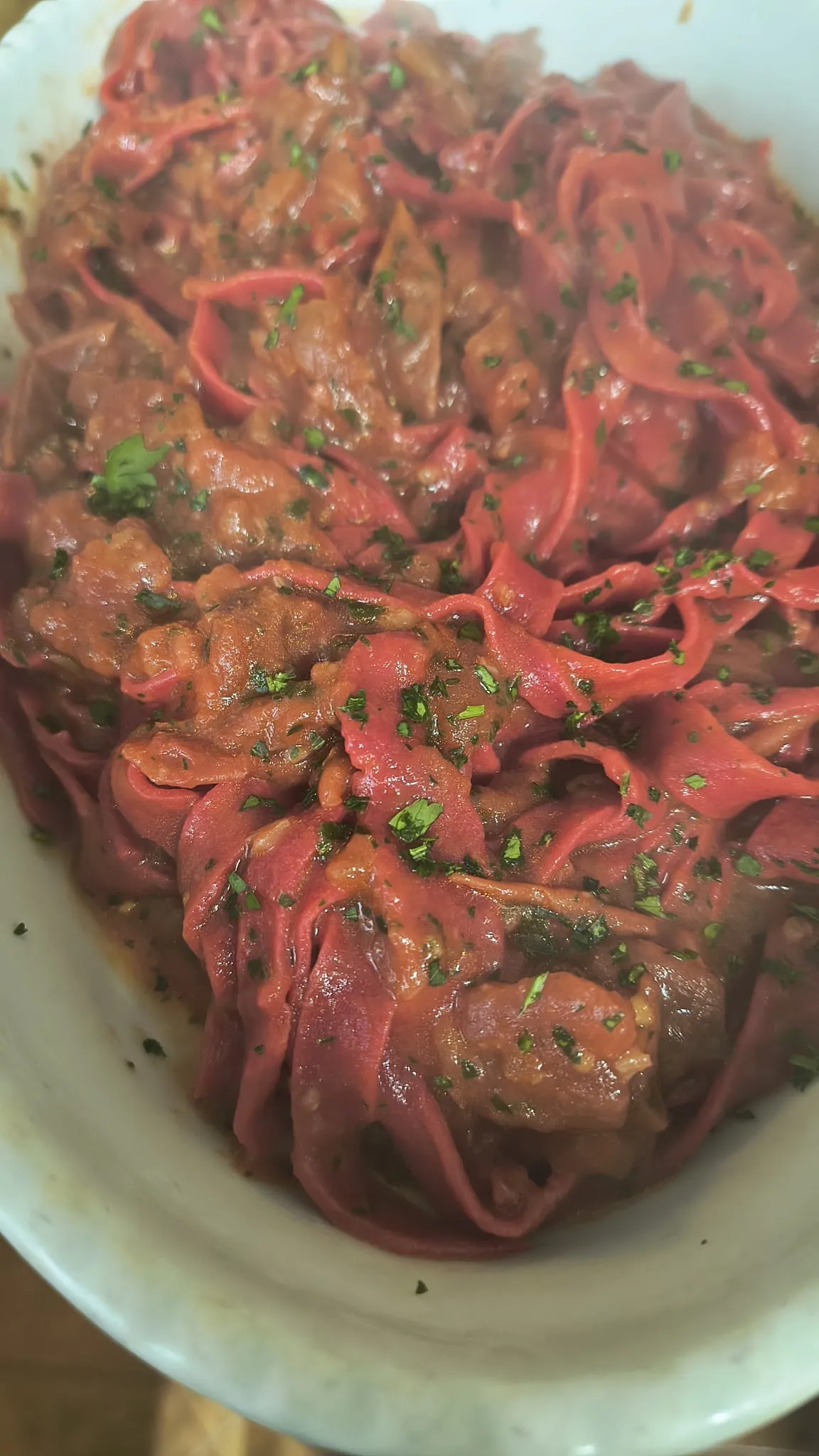 Tagliatelle rosse in un piatto bianco