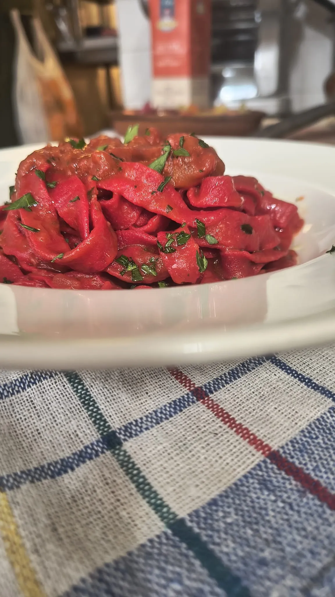Tagliatelle rosse con prezzemolo, in un piatto fondo bianco