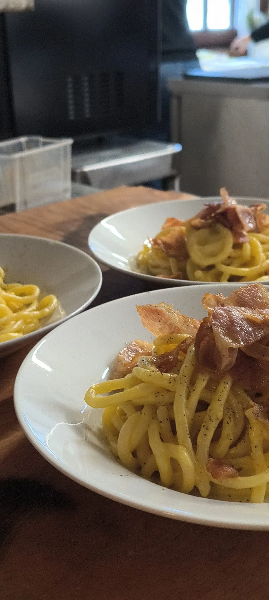Pasta con guanciale croccante servita in piatti fondi