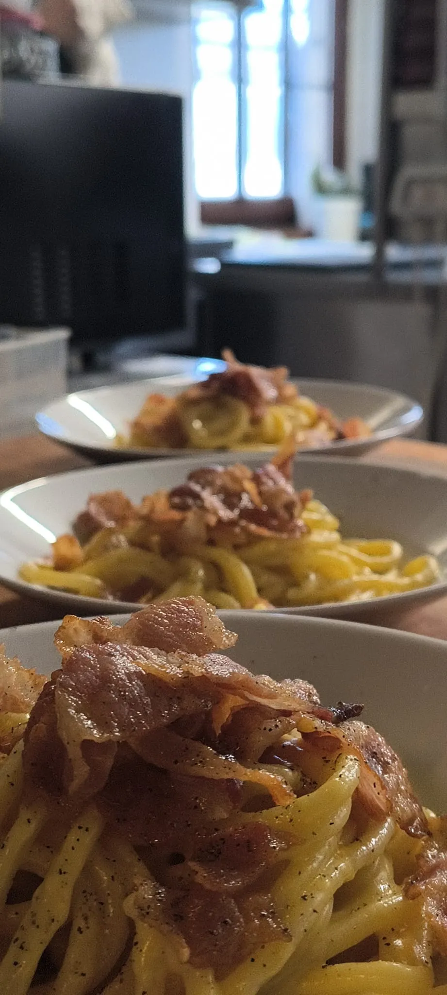 Pasta con guanciale in una fila di piatti pronti