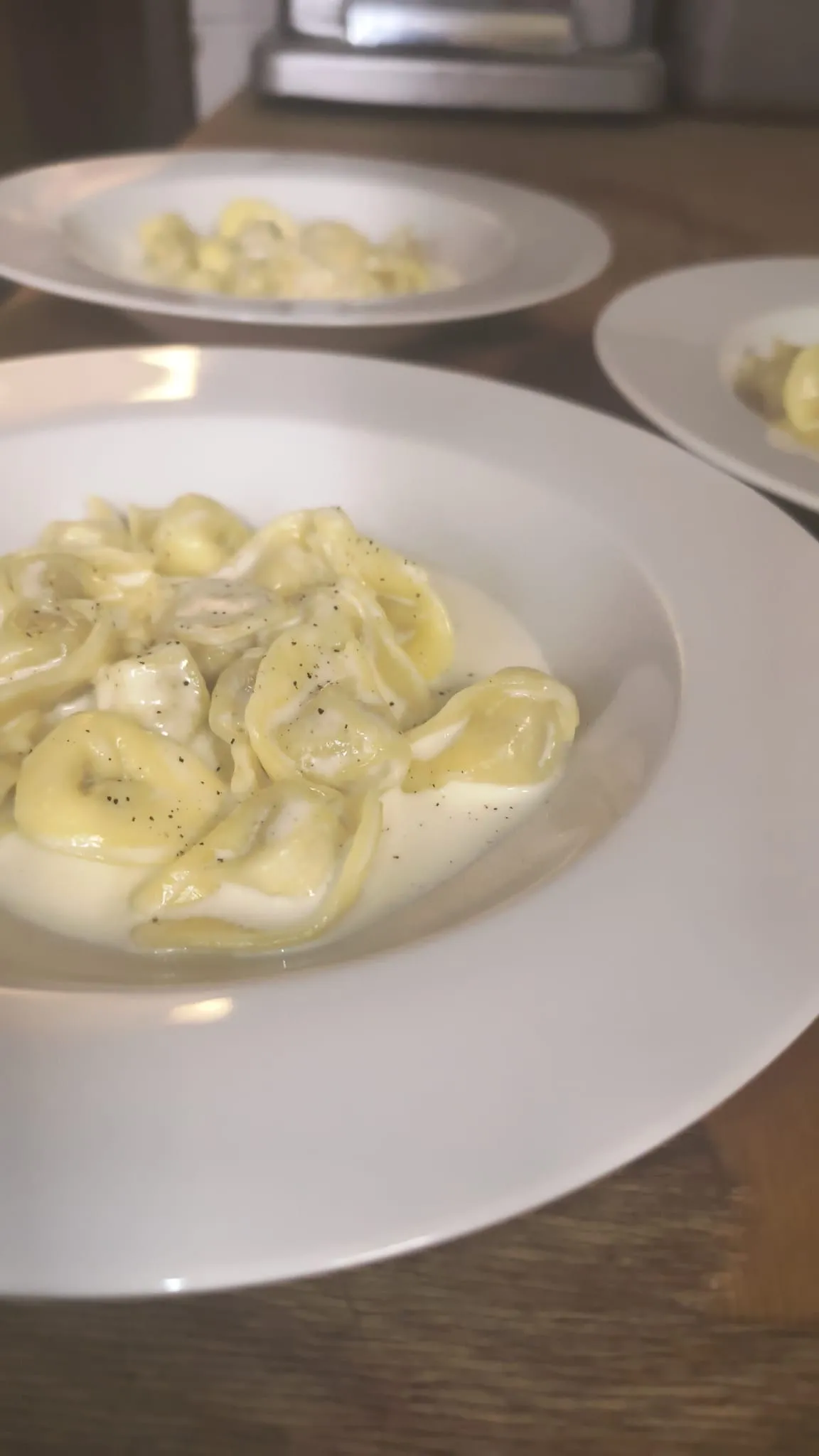Tortelli conditi in un piatto bianco
