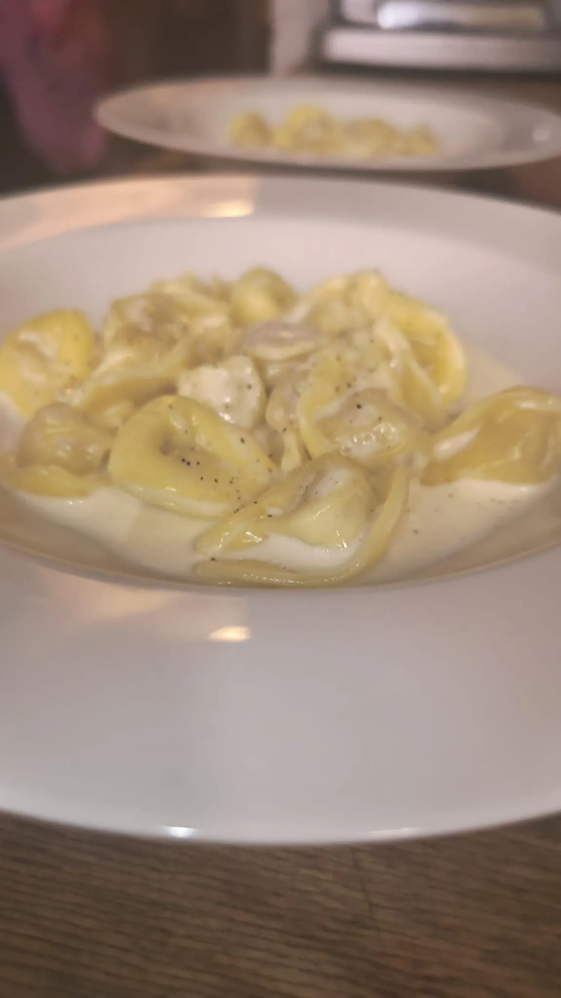Tortelli in un piatto bianco su un tavolo di legno